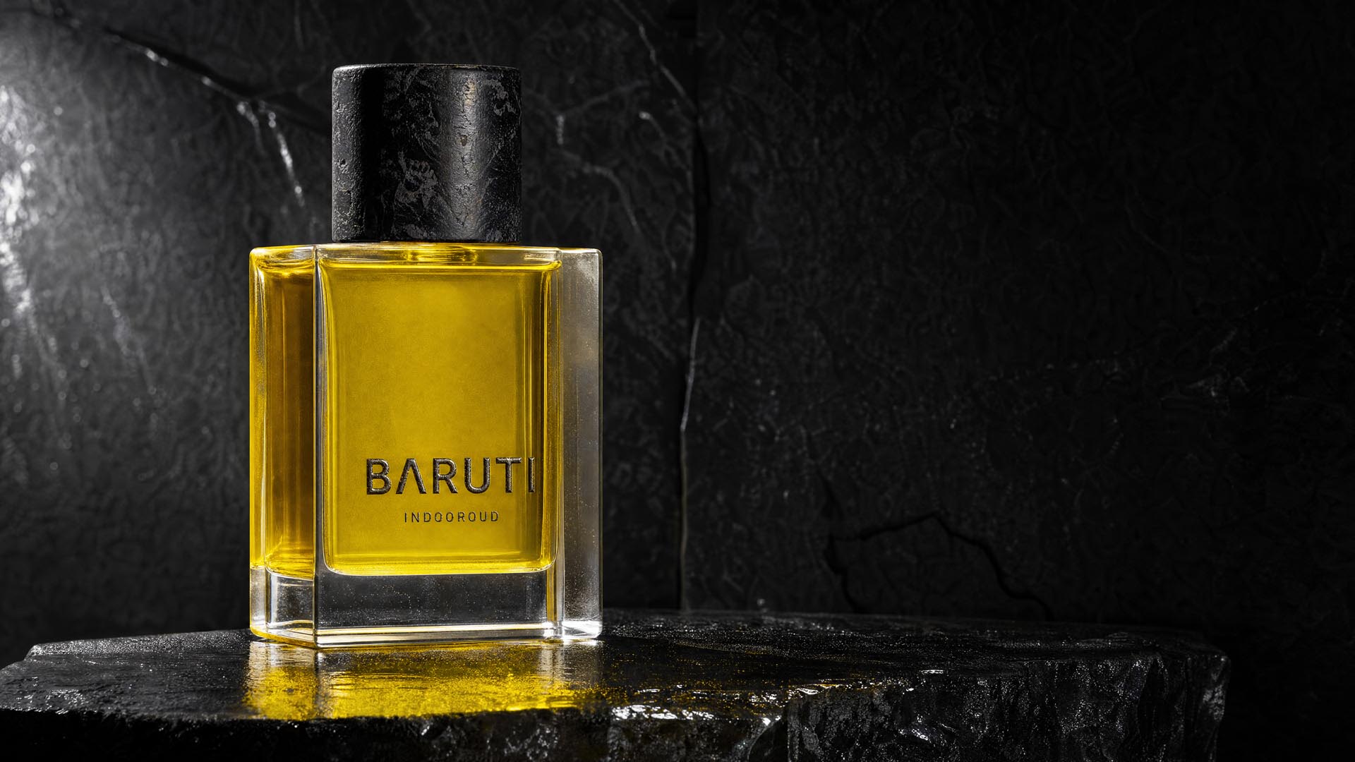 Perfume bottle in a lit packshot on dark stone